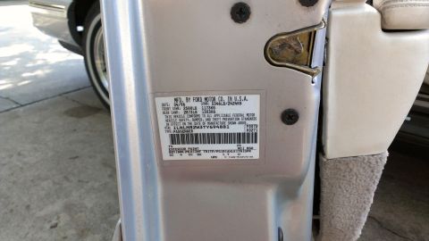 1996 Lincoln Town Car - Close-up of a vehicle's door jamb sticker showing manufacturing details and VIN.