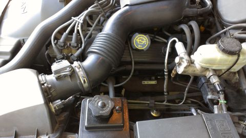 1996 Lincoln Town Car - Close-up view of a vehicle's engine bay, showing various components including the oil cap and brake fluid reservoir.