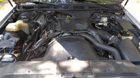 1996 Lincoln Town Car - The engine compartment of a car is shown with various components and wiring visible.