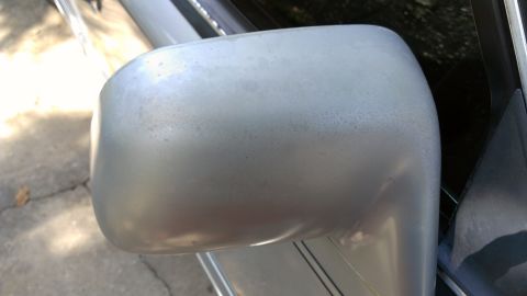 1996 Lincoln Town Car - Close-up of a silver side mirror showing signs of age and wear.