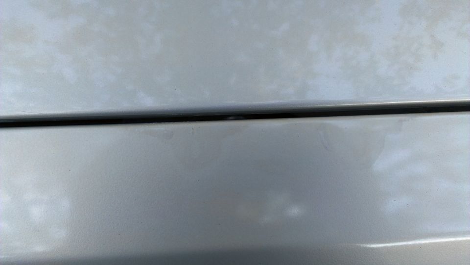 Silver car panel with black trim line, Supermotors logo visible
