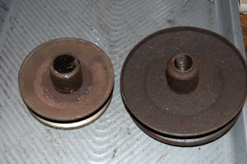 2006 Honda RANCHER - Two rusty pulleys, one smaller with a white band and one larger, are displayed on a textured gray surface.