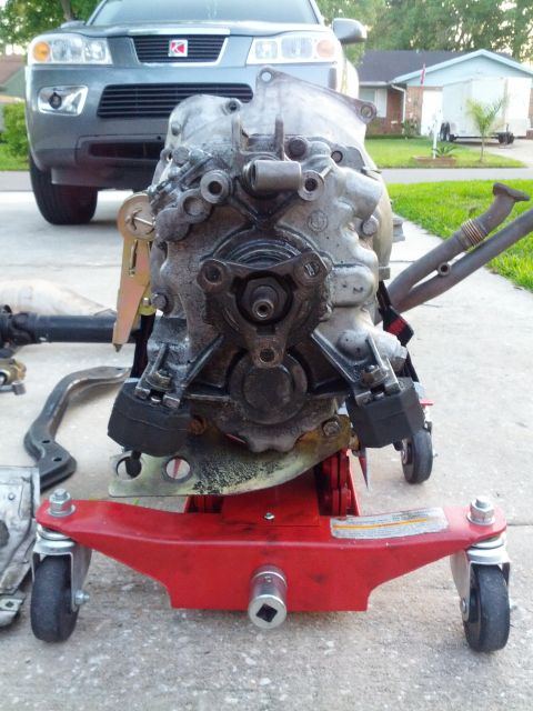 1989 BMW 3 Series - Transmission unit on a red dolly, with a Saturn Vue SUV visible in the background.