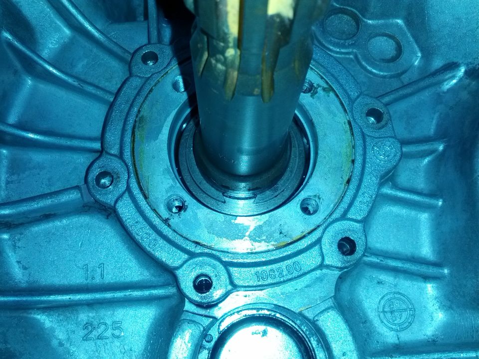 Close-up of a metal transmission housing with a shaft extending from the center