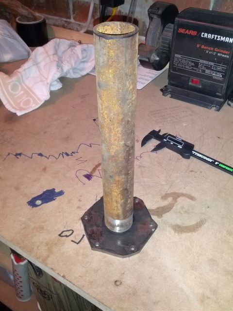 1989 BMW 3 Series - A rusted metal pipe assembly sits on a workbench next to a digital caliper and a Sears Craftsman bench grinder.