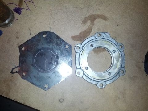1989 BMW 3 Series - Two metal transmission parts are laid out on a wooden surface, possibly for repair or inspection.