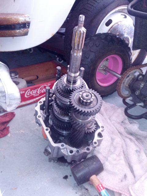 1989 BMW 3 Series - A close-up view of disassembled transmission gears, with a rubber mallet nearby.
