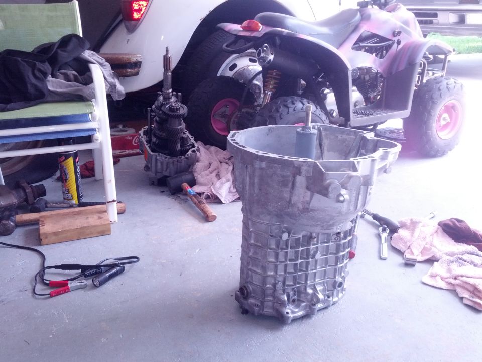 Aluminum transmission casing and gearbox on a concrete floor with an ATV in the background