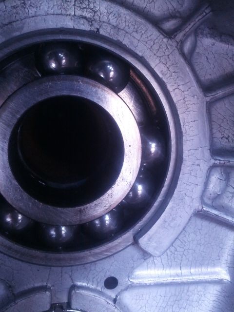 1989 BMW 3 Series - Close-up of a ball bearing in a damaged metal casing with visible cracks.