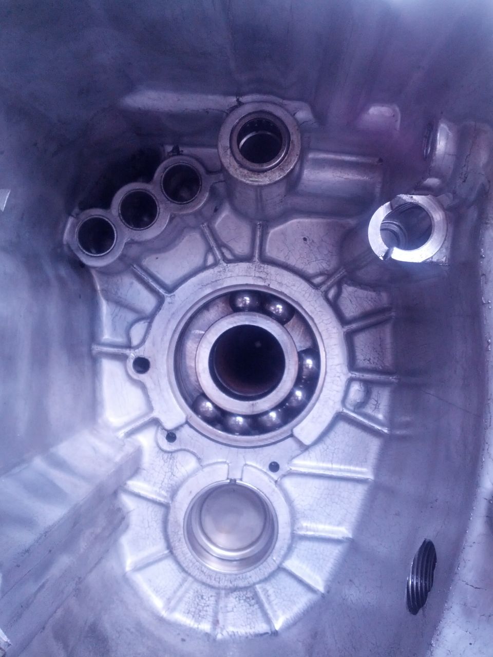 Interior view of a transmission housing showing ball bearings and mounting points