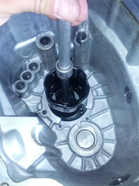 1989 BMW 3 Series - A tool is used to extract a component from the interior of a transmission casing.