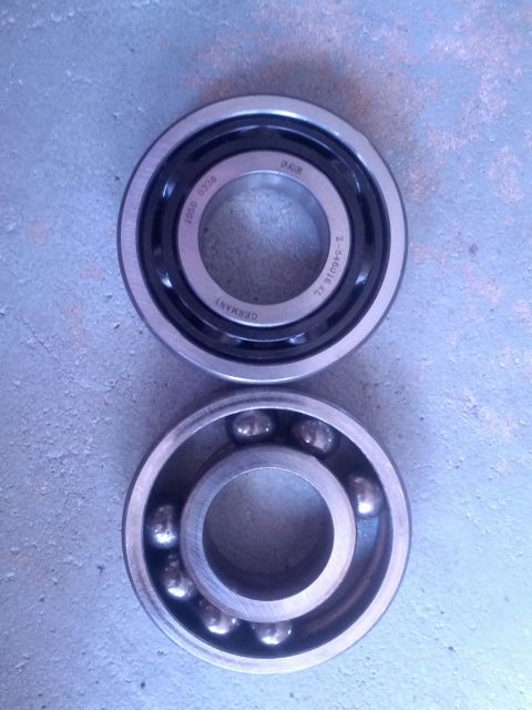 1989 BMW 3 Series - A close-up view of two ball bearings, one sealed and one open, resting on a textured surface.