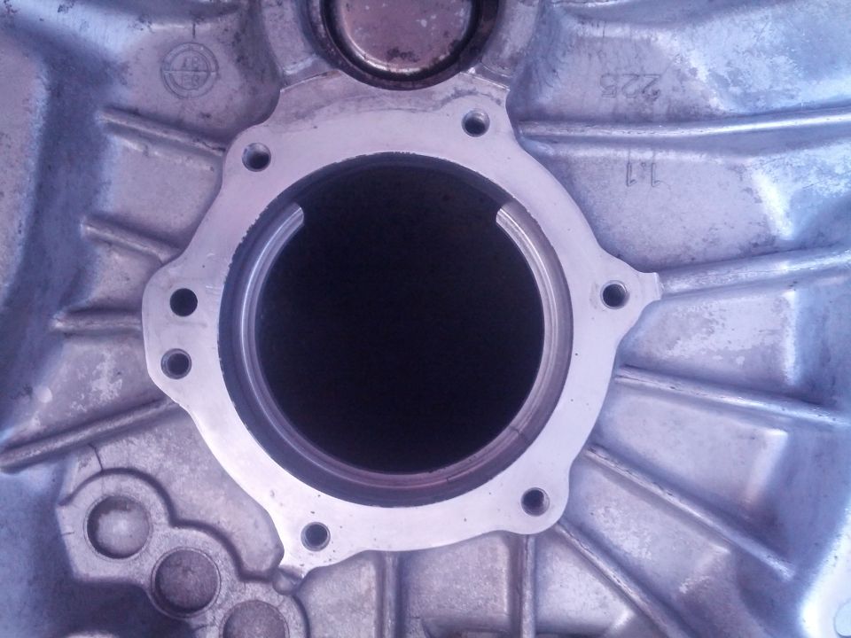 Transmission housing part with circular opening and bolt holes