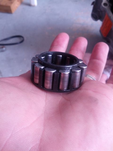 1989 BMW 3 Series - A roller bearing is held in a hand, with a website logo in the corner.