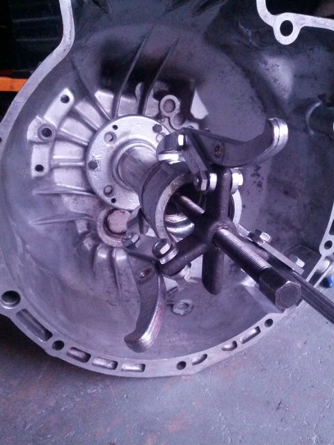 1989 BMW 3 Series - Close-up of a transmission bell housing with a clutch release mechanism tool engaged.