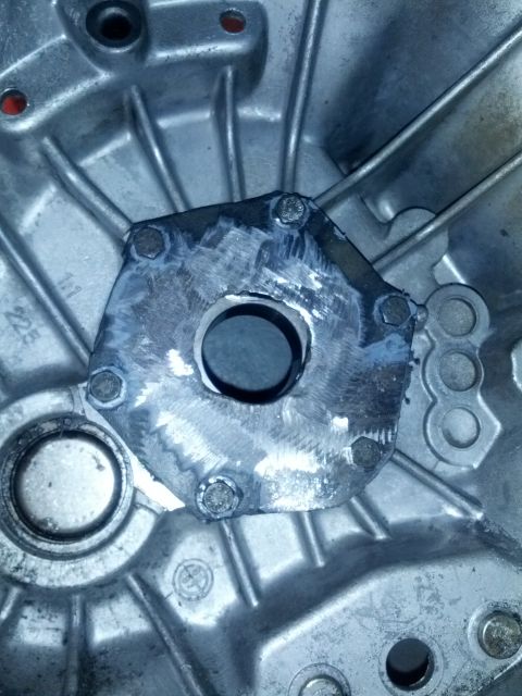 1989 BMW 3 Series - This is a close-up view of a modified transmission housing, showing a central opening and bolted metal plate.