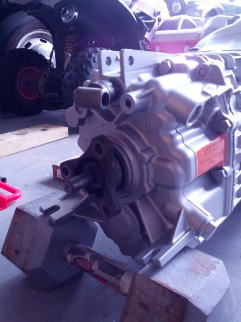 1989 BMW 3 Series - Silver BMW transmission housing with a red label, resting on blocks.