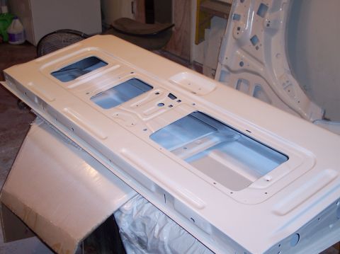 1990 Ford Bronco - Unpainted car door panel with multiple cutouts, likely for window and interior components.