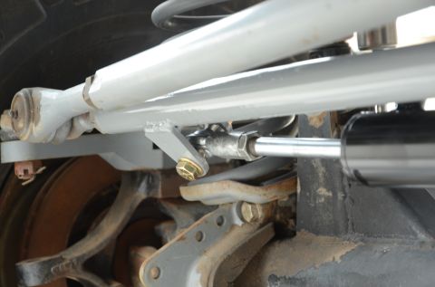 1979 Ford Bronco - This image shows a close-up view of the steering stabilizer and tie rod assembly, part of a vehicle's suspension system.