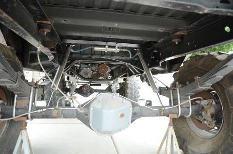 1979 Ford Bronco - The underside of a 4x4 vehicle is shown, highlighting its heavy-duty suspension and drivetrain components.