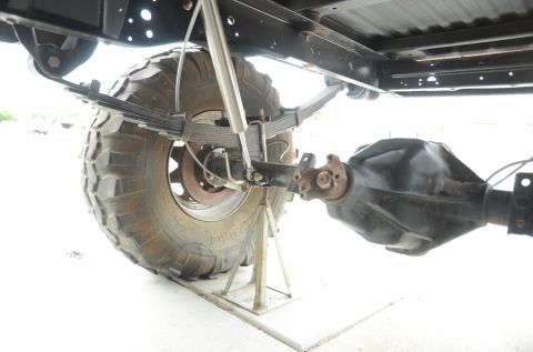 1979 Ford Bronco - Close-up view of a vehicle's rear axle and suspension components, including leaf springs and a shock absorber.