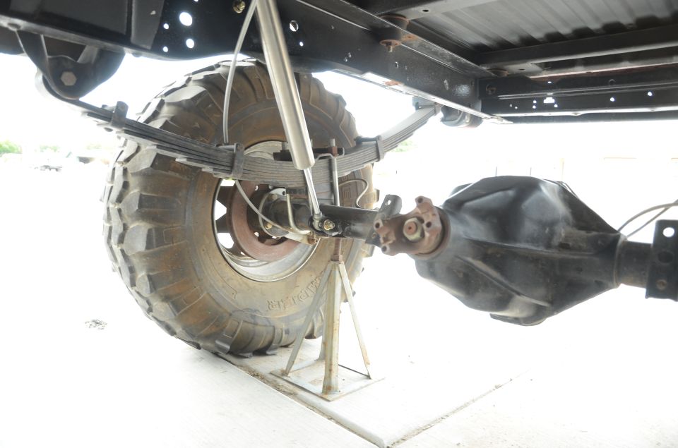 rear axle, leaf springs, and shock absorber on a vehicle supported by jack stands