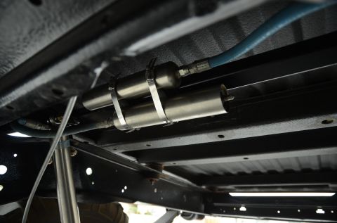 1979 Ford Bronco - Close-up view of the undercarriage of a vehicle, highlighting its suspension components and a visible website logo.