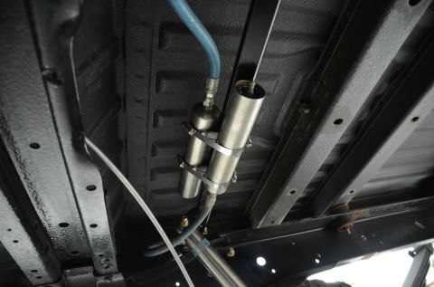 1979 Ford Bronco - Close-up of the undercarriage showing shocks and air suspension system components, including a blue hose.