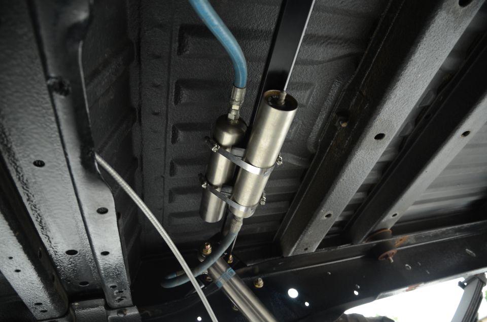 Underbody view of shocks and air suspension components with blue hose