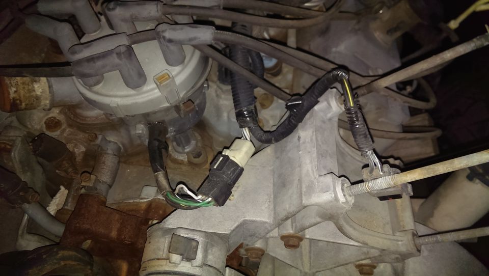 Close-up of an engine distributor with spark plug wires and electrical connectors