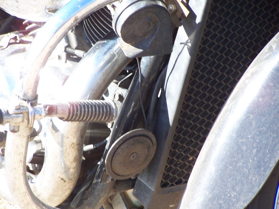 Motorcycle horn and radiator grille with chrome pipes and a ribbed footpeg