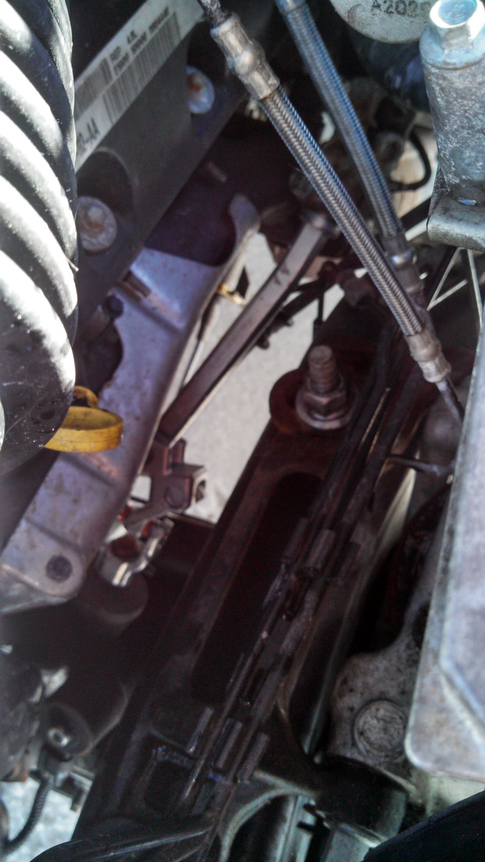 Close-up of a vehicle's steering shaft assembly with braided hoses and bolts