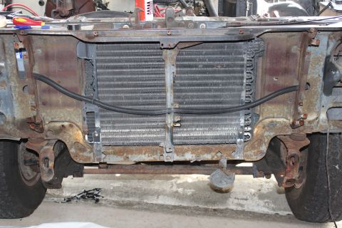 1982 Ford Bronco - The front end of a heavily rusted vehicle, showing the radiator and surrounding frame components.