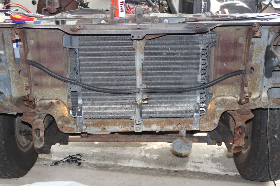 Radiator and front frame of a rusty 1980s truck, viewed from the front