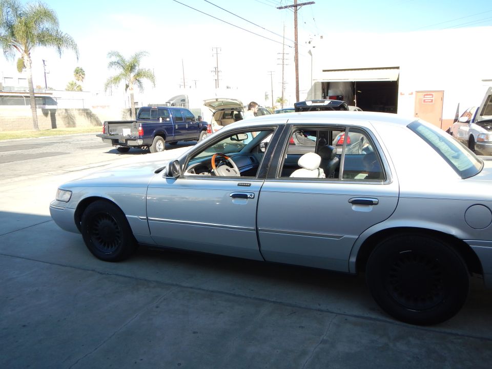Side profile of silver Mercury sedan with black wheels in an industrial lot