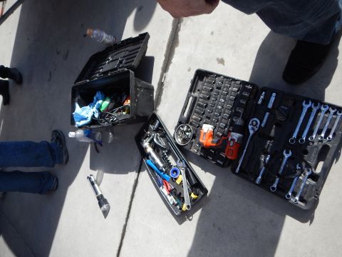 2003 Ford Crown Victoria - open mechanic's tool case and socket set spread out on a concrete floor next to a toolbox and a person's feet.