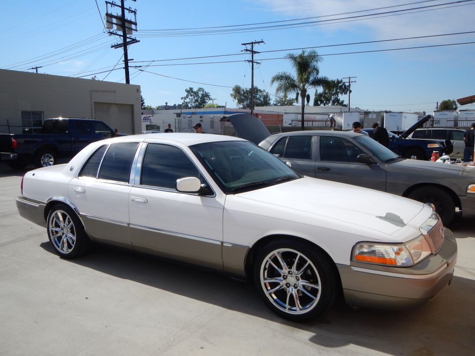 White Mercury Grand Marquis sedan front quarter with chrome wheels