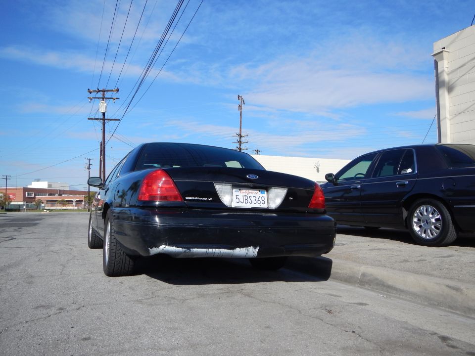 Rear of a black Ford Crown Victoria sedan with California plate