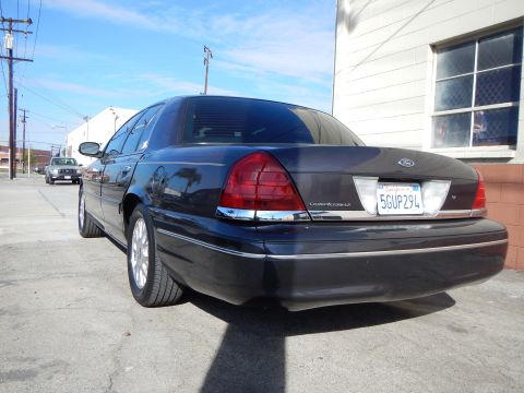 2003 Ford Crown Victoria - dark blue Ford Crown Victoria LX shown from the rear with its trunk badge, Ford emblem and California license plate 5GUP294.