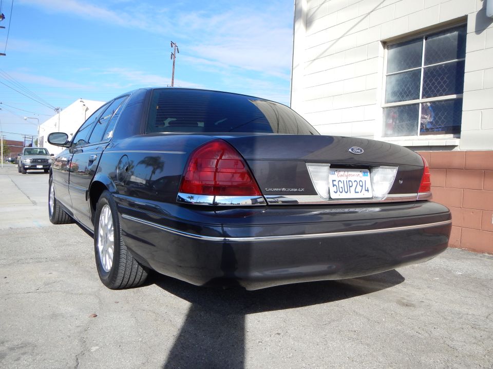 Rear three-quarter of a dark Ford Crown Victoria LX sedan