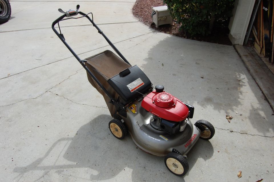Honda lawn mower with red engine and brown bagger