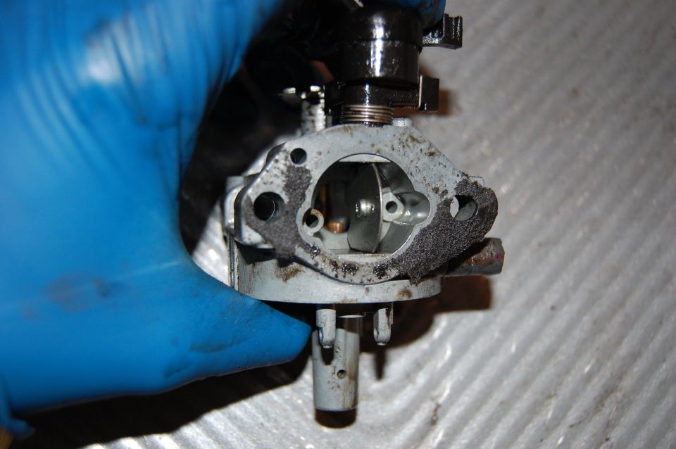 Carburetor held by gloved hand
