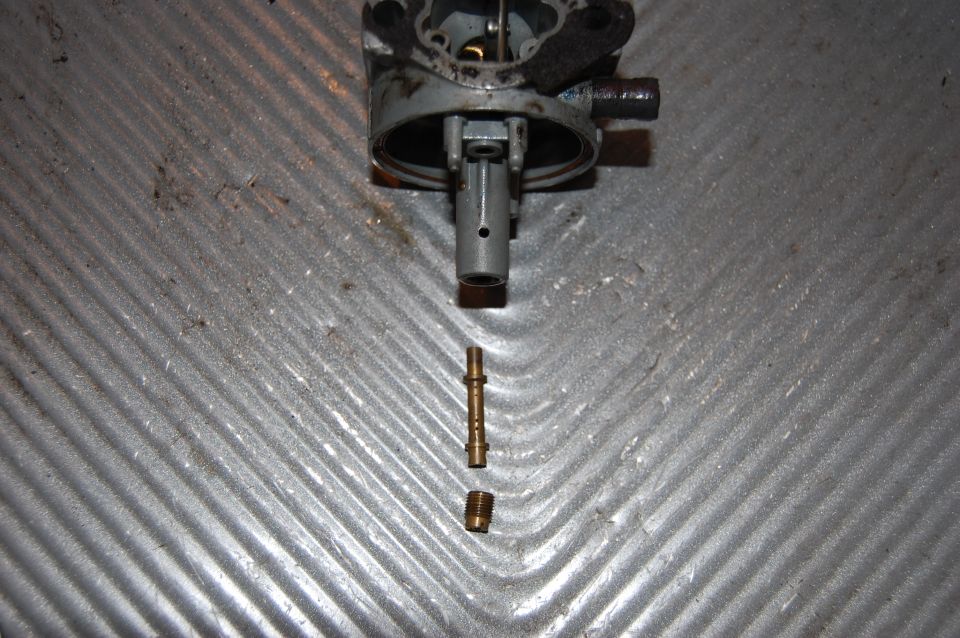 carburetor disassembled with brass jet and nut