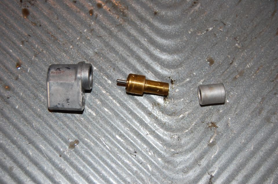 Disassembled carburetor parts on a textured surface