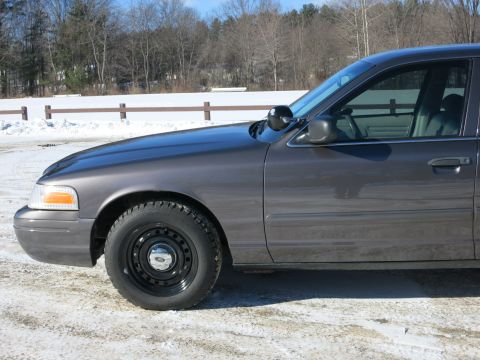 2001 Ford Crown Victoria - Side profile of a gray 2001 Ford Crown Victoria sedan parked in a snowy area.