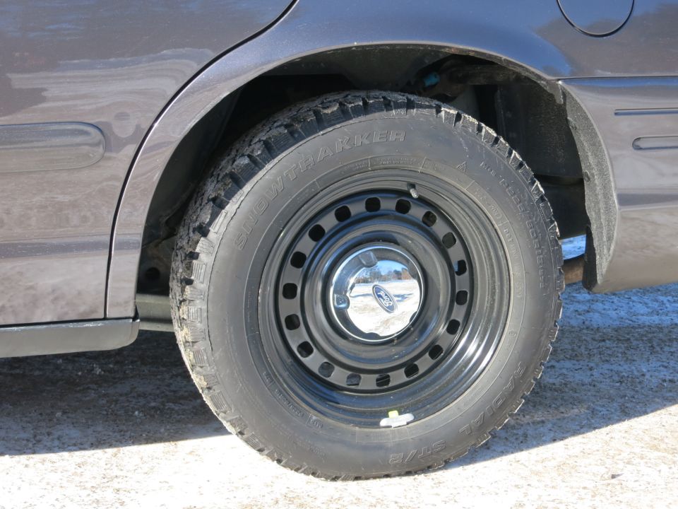 2001 Ford Crown Victoria rear wheel with steel rim and snow tire