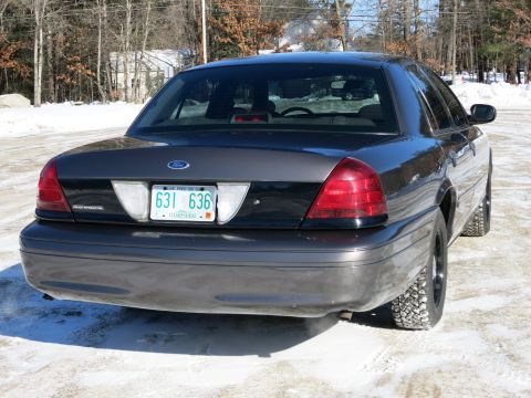 2001 Ford Crown Victoria - The rear of a dark gray Ford Crown Victoria is shown with a New Hampshire license plate in a snowy environment.