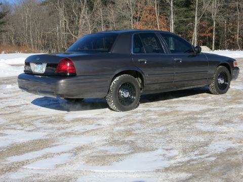 2001 Ford Crown Victoria - This 2001 Ford Crown Victoria sedan is seen from the rear three-quarter angle on a partially snow-covered road.