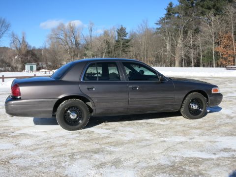 2001 Ford Crown Victoria - A gray 2001 Ford Crown Victoria is parked outside on a cold, snowy day.