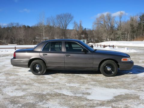 2001 Ford Crown Victoria - Side profile of a 2001 Ford Crown Victoria sedan in a winter setting.